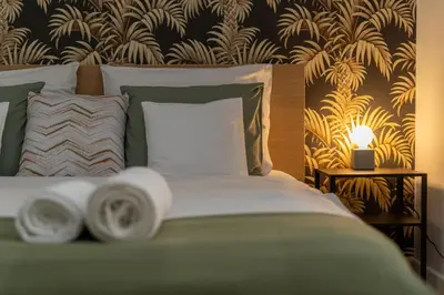 a bedroom with a bed and a night stand with a lamp at Old Town Luxe Retreat - King Bed - Steps to Main Square in Kraków