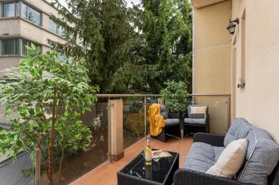 a patio with two couches and a table and trees at Old Town Luxe Retreat - King Bed - Steps to Main Square in Kraków