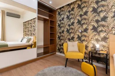 a bedroom with a bed and a yellow chair at Old Town Luxe Retreat - King Bed - Steps to Main Square in Kraków