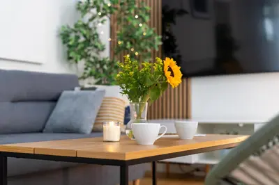 a wooden table with a vase of flowers on it at Old Town Luxe Retreat - King Bed - Steps to Main Square in Kraków