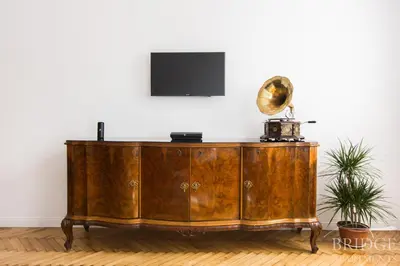 a wooden cabinet in a room with a television on top at Bridge Apartments in Kraków