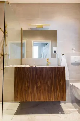 a bathroom with a wooden sink and a mirror at Bridge Apartments in Kraków