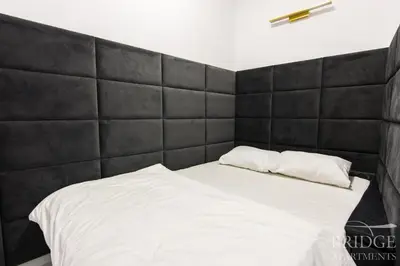 a bed with a black headboard in a room at Bridge Apartments in Kraków