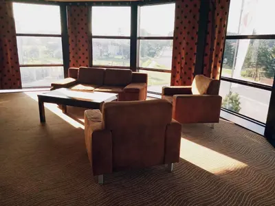 a living room with couches and a table and windows at Hotel Azalia & Spa in Niepołomice