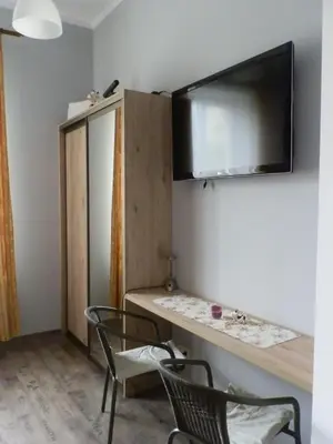 a room with two chairs and a tv on the wall at Studio Na Powiślu in Kraków
