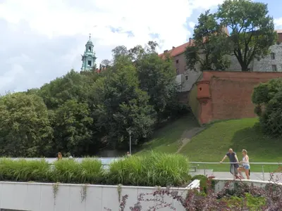 two people walking on a sidewalk next to a building at Studio Na Powiślu in Kraków