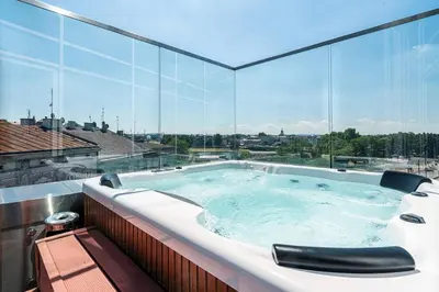 a hot tub in a building with a large window at Aparthotel Best Views in Kraków
