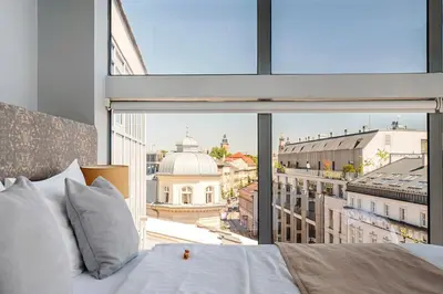 a bedroom with a large window looking out at a building at Aparthotel Best Views in Kraków