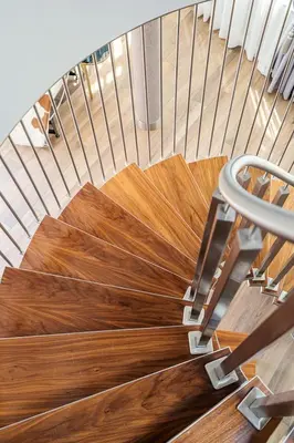 a spiral staircase with wood floors and a metal railing at Aparthotel Best Views in Kraków