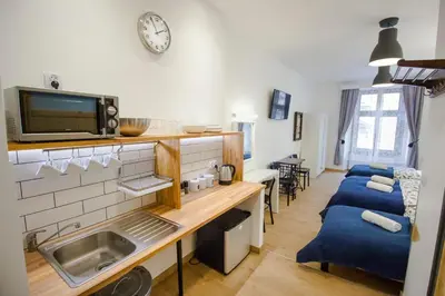 a kitchen with a sink and a tv on the wall at Pokoje Gościnne Św. Anny in Kraków