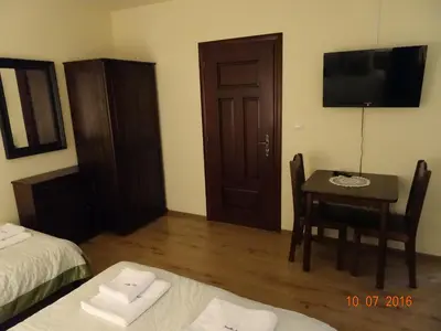 a room with a table and a television and a bedroom at ZłotyOgród in Wieliczka