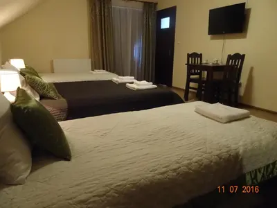 a hotel room with two beds and a table at ZłotyOgród in Wieliczka