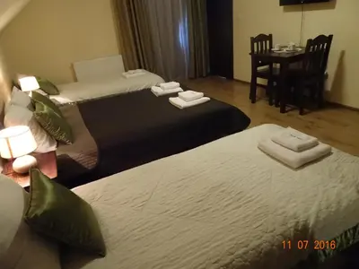 two beds in a hotel room with a table and chairs at ZłotyOgród in Wieliczka