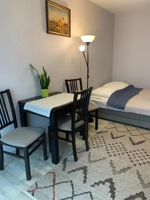 a dining room with a table and chairs and a bed at Apartament Łagiewniki Krakow in Kraków