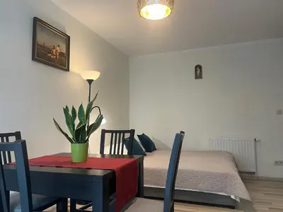 a room with a table and a bed and a table and chairs at Apartament Łagiewniki Krakow in Kraków