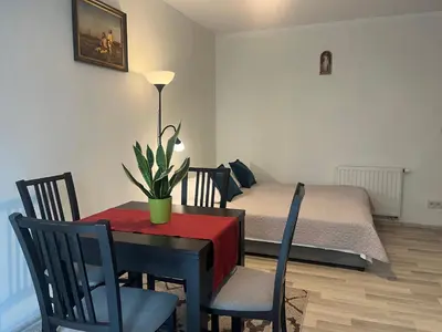 a dining room with a table and a bed at Apartament Łagiewniki Krakow in Kraków