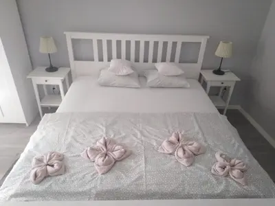 a bed with pink bows on it with two tables at Apartment Oświęcim klimatyzowany in Oświęcim