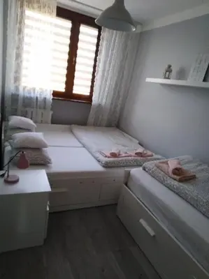 a small bedroom with two beds and a window at Apartment Oświęcim klimatyzowany in Oświęcim