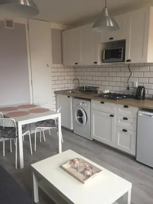 a kitchen with a table and a stove top oven at Apartment Oświęcim klimatyzowany in Oświęcim