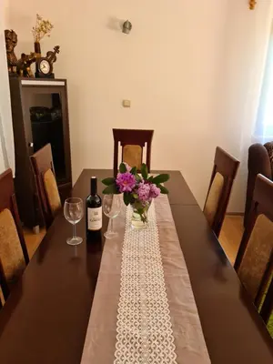 a table with a bottle of wine and flowers on it at Forest House in Lubomierz