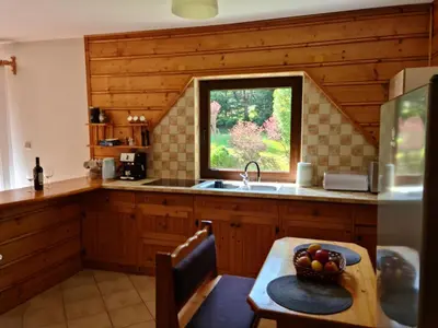 a kitchen with a table and a sink and a window at Forest House in Lubomierz