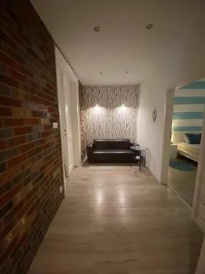 a living room with a couch and a brick wall at Apartament Vistula in Kraków