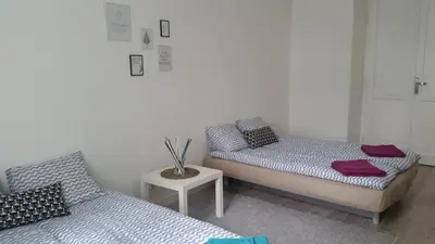 a room with two beds and a side table with a table at Apartament Vistula in Kraków