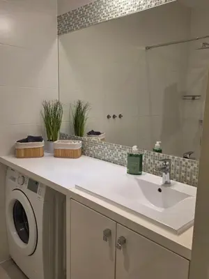 a bathroom with a sink and a washing machine at Apartament Vistula in Kraków