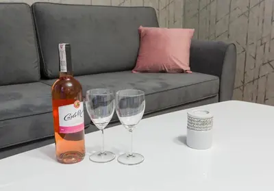 a bottle of wine and two wine glasses on a table at AR Apartments - Angel Center Kraków in Kraków