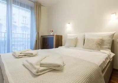 a bedroom with a white bed with towels on it at AR Apartments - Angel Center Kraków in Kraków