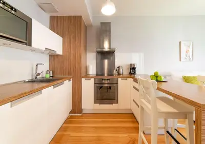 a kitchen with white cabinets and a wooden counter top at AR Apartments - Angel Center Kraków in Kraków