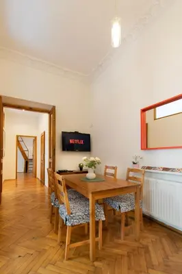 a dining room with a wooden table and chairs at Ground Floor Family Apartment in Kraków