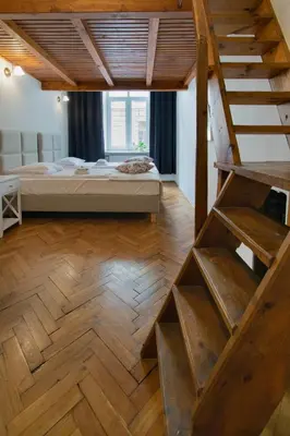 a bedroom with a bed and a wooden floor at Ground Floor Family Apartment in Kraków