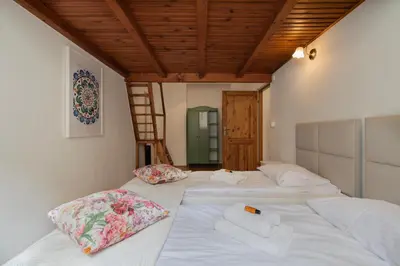 a room with three beds with pillows and a ladder at Ground Floor Family Apartment in Kraków
