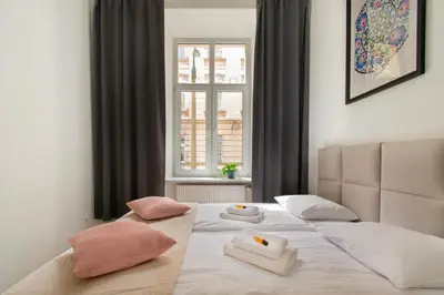 a bedroom with a bed with two pillows and a window at Ground Floor Family Apartment in Kraków