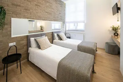 a bedroom with two beds and a brick wall at Beautiful Apartment with 2 bedrooms for 7 guests, Jewish District in Kraków