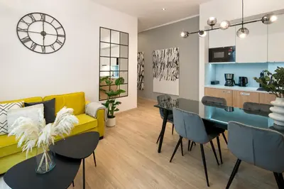 a living room with a yellow couch and a table at Beautiful Apartment with 2 bedrooms for 7 guests, Jewish District in Kraków