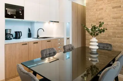 a kitchen with a table with chairs and a vase at Beautiful Apartment with 2 bedrooms for 7 guests, Jewish District in Kraków