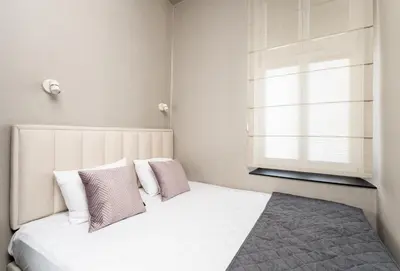 a bedroom with a white bed with pillows and a window at Erasmus Student Apartments - Old Town in Kraków