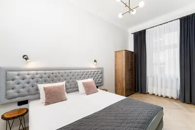 a bedroom with a large bed and a large window at Erasmus Student Apartments - Old Town in Kraków
