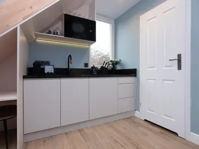 a kitchen with white cabinets and a white door at Erasmus Student Apartments - Old Town in Kraków