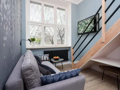 a living room with a couch and a staircase at Erasmus Student Apartments - Old Town in Kraków