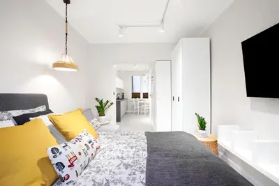 a bedroom with a bed with yellow pillows at Rakowicka 71 Partnerapart in Kraków