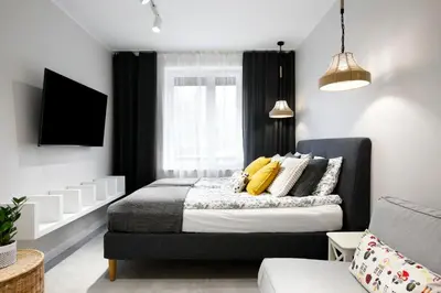 a bedroom with a bed with yellow pillows at Rakowicka 71 Partnerapart in Kraków