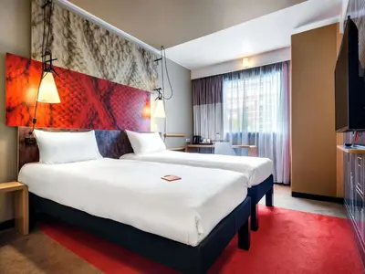a bedroom with a large bed and a window at Hotel Ibis Krakow Centrum in Kraków