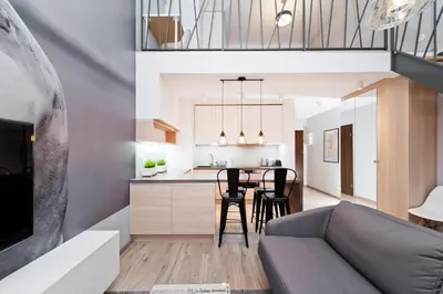 a living room and kitchen with a couch and a table at Olimp Apartments in Kraków