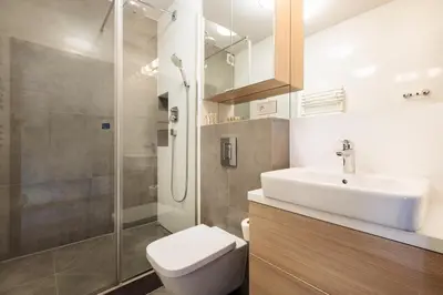 a bathroom with a toilet and a sink and a shower at Olimp Apartments in Kraków