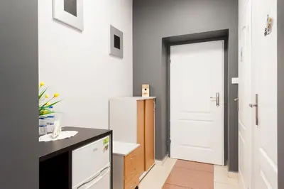 a kitchen with a white refrigerator and a white door at Apartament Solny Wieliczka Centrum 5 in Wieliczka