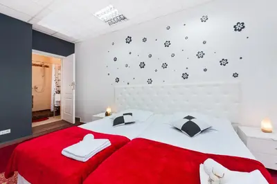 a bedroom with a red blanket and a white bed at Apartament Solny Wieliczka Centrum 5 in Wieliczka