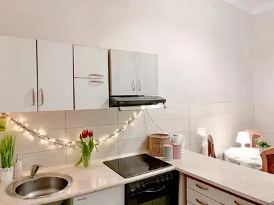 a kitchen with a sink and a counter with lights at Hostel u Kmity in Kraków